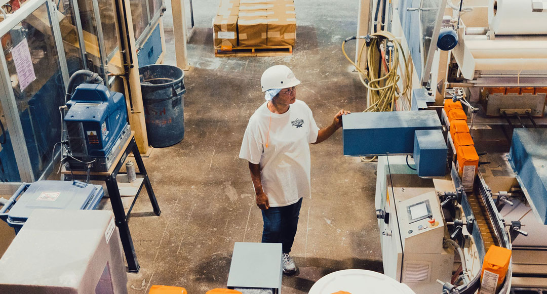 Farmer Direct Foods employee Hong Terry oversees a conveyor belt of King Arthur Flour in New Cambria, Kan.
