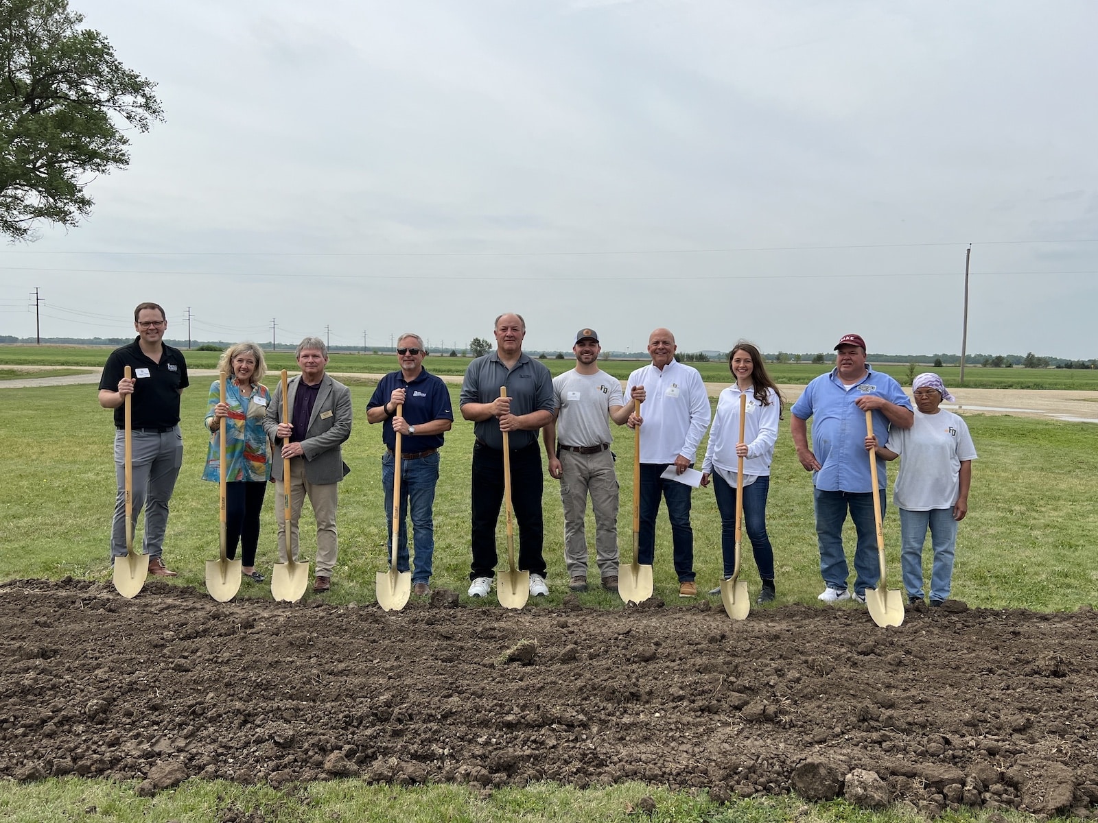 Photo of Farmer Direct Foods leadership, employees, local officials, and customers standing with shovels.